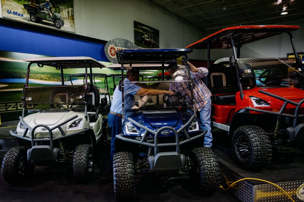 Golf Cars of Houston Superstore sales consultant and a client take a look at a golf cart