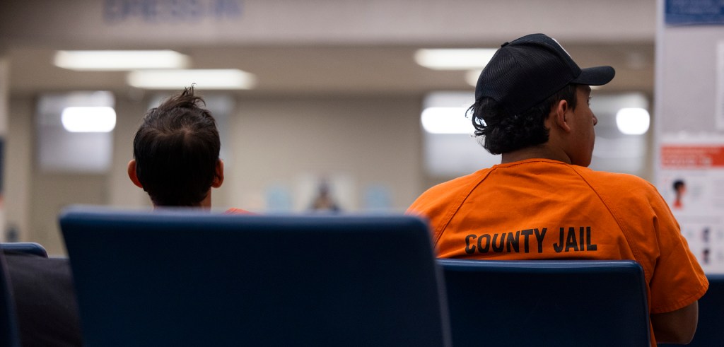 People wait in the Harris County Joint Processing Center.