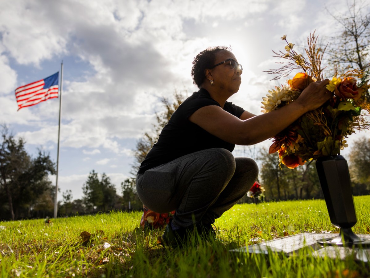 Rowena Ward the replaces flowers on the gravestone belonging to her son, Rory Ward at the cemetery.