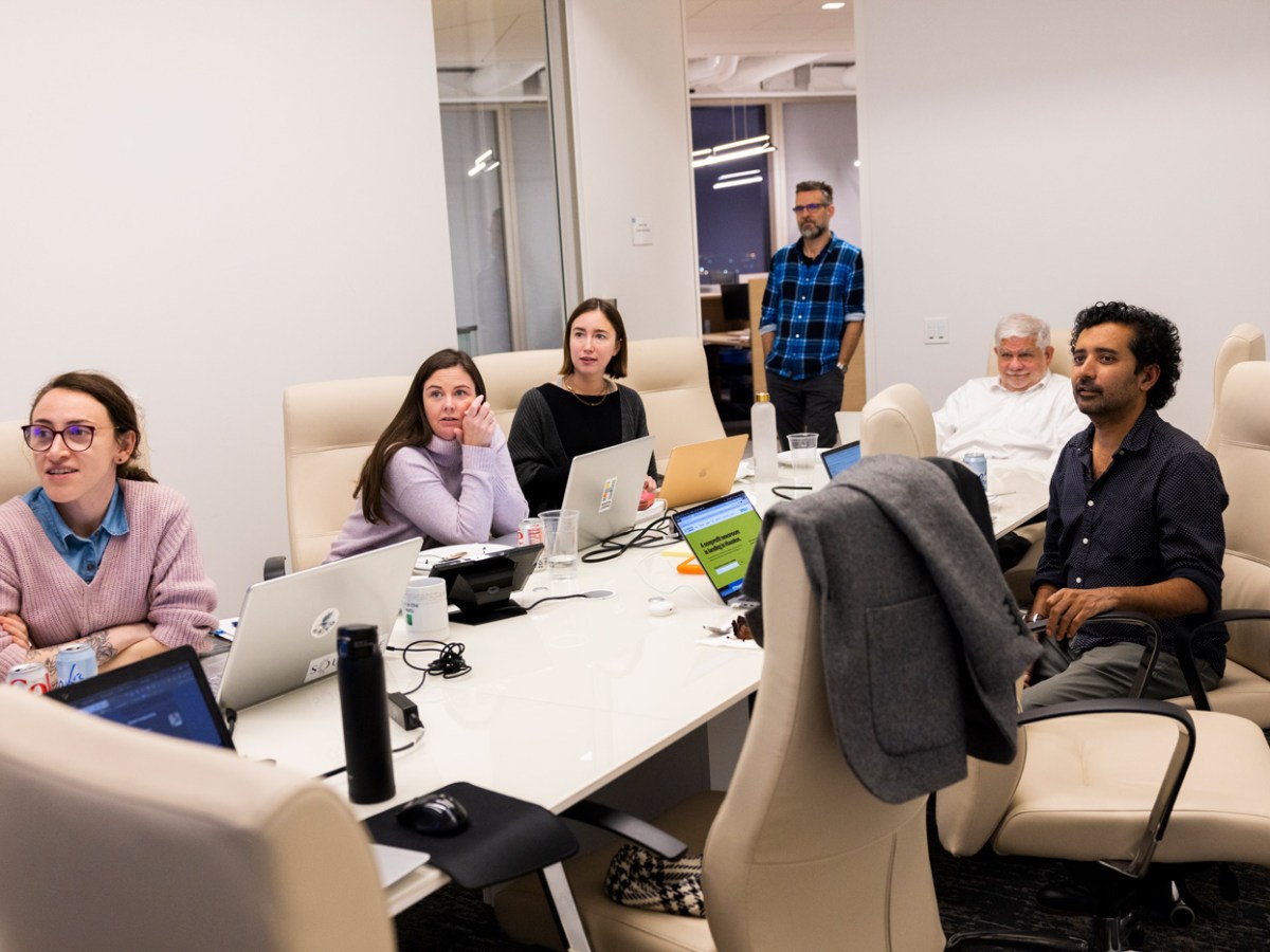 The Houston Landing team gathers around a conference room table the night before their website launched on Feb. 1, 2023, in Houston.