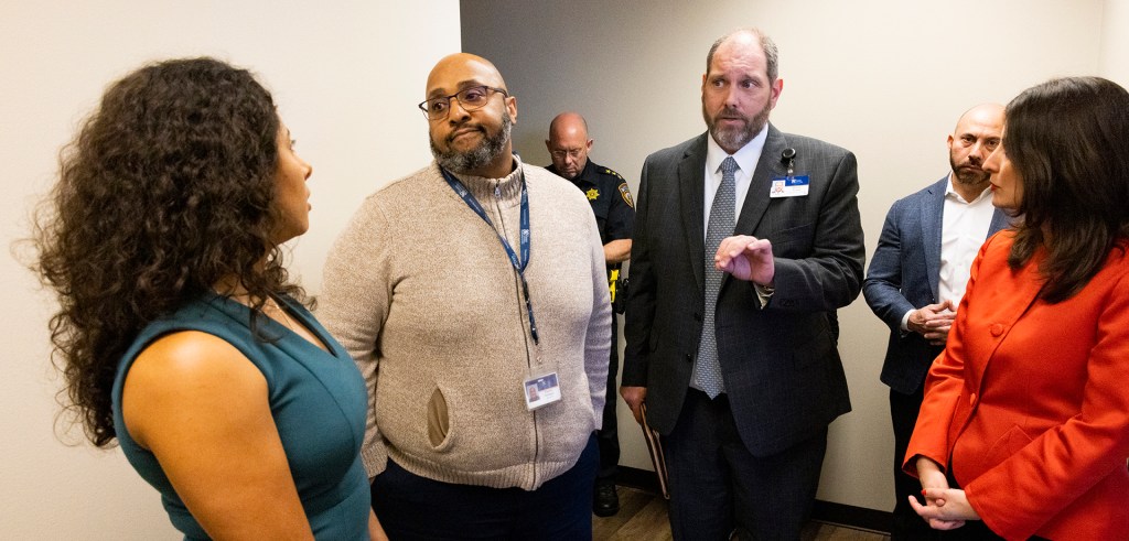 The Harris Center for Mental Health and IDD CEO Wayne Young, center, answers Harris County judge Lina Hidalgo questions during a visit to the Harris Center facilities before a press conference.