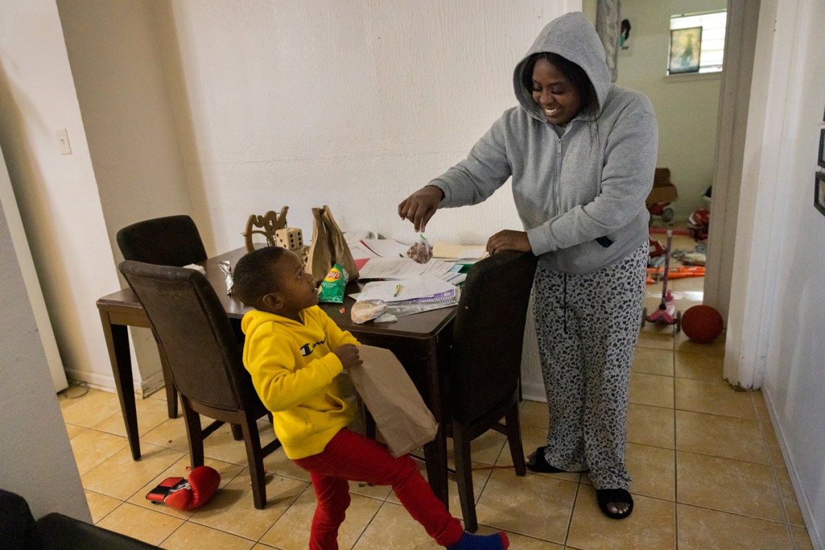 Mother gives a snack to her son.