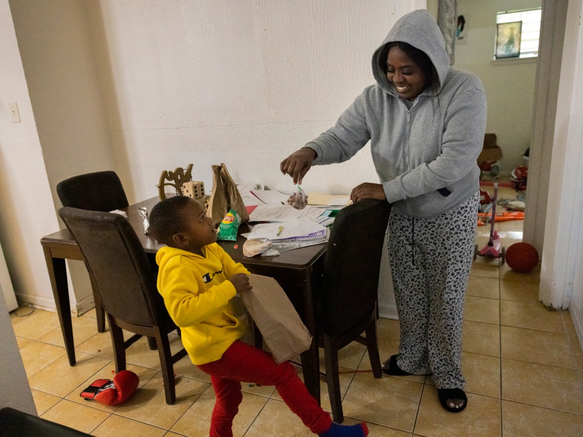 Mother gives a snack to her son.