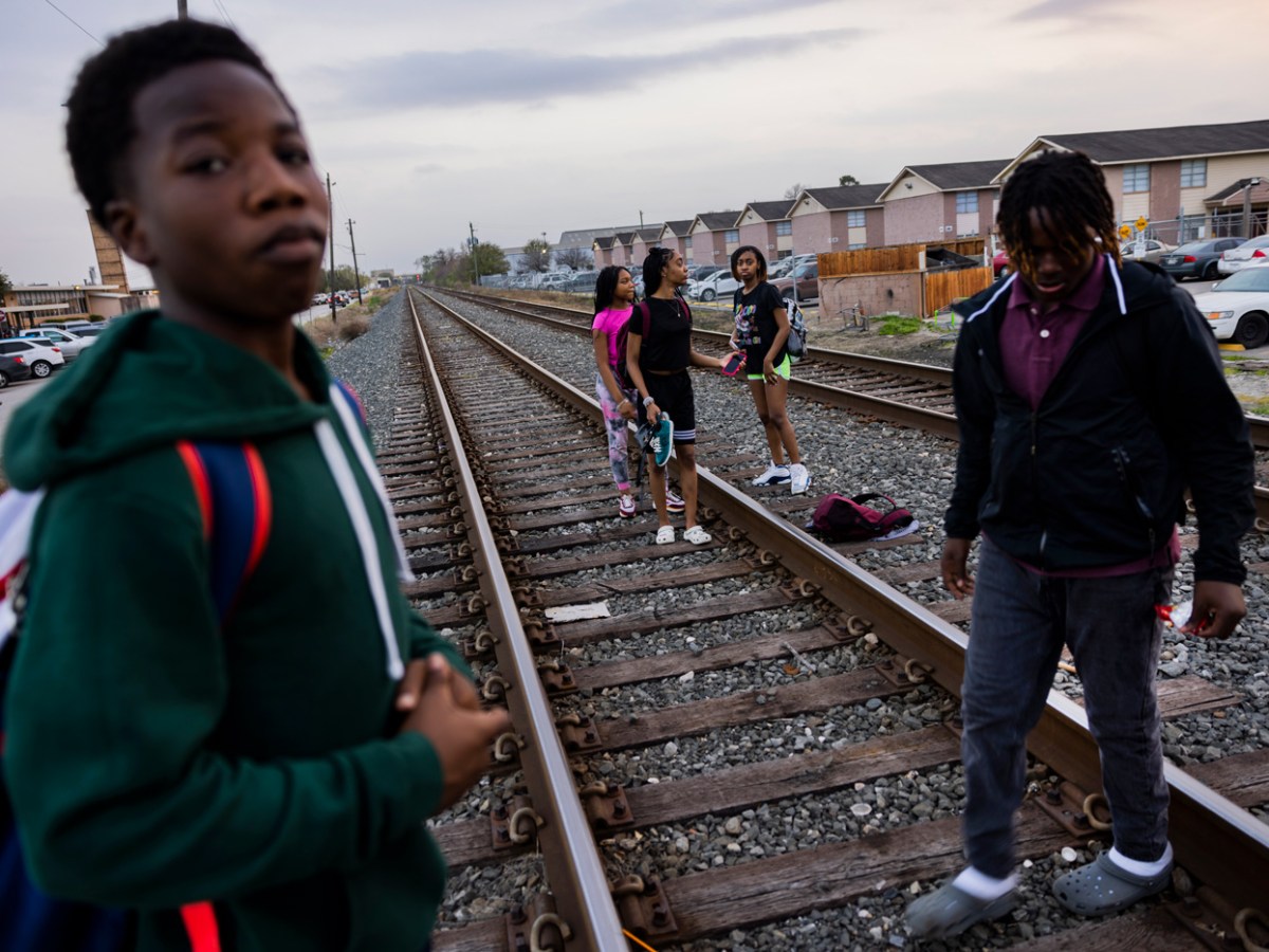 Students walk over railroad tracks