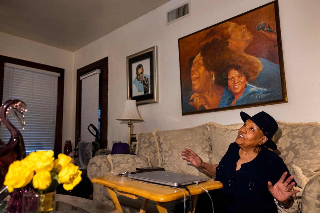 Female songwriter sings in her living room.