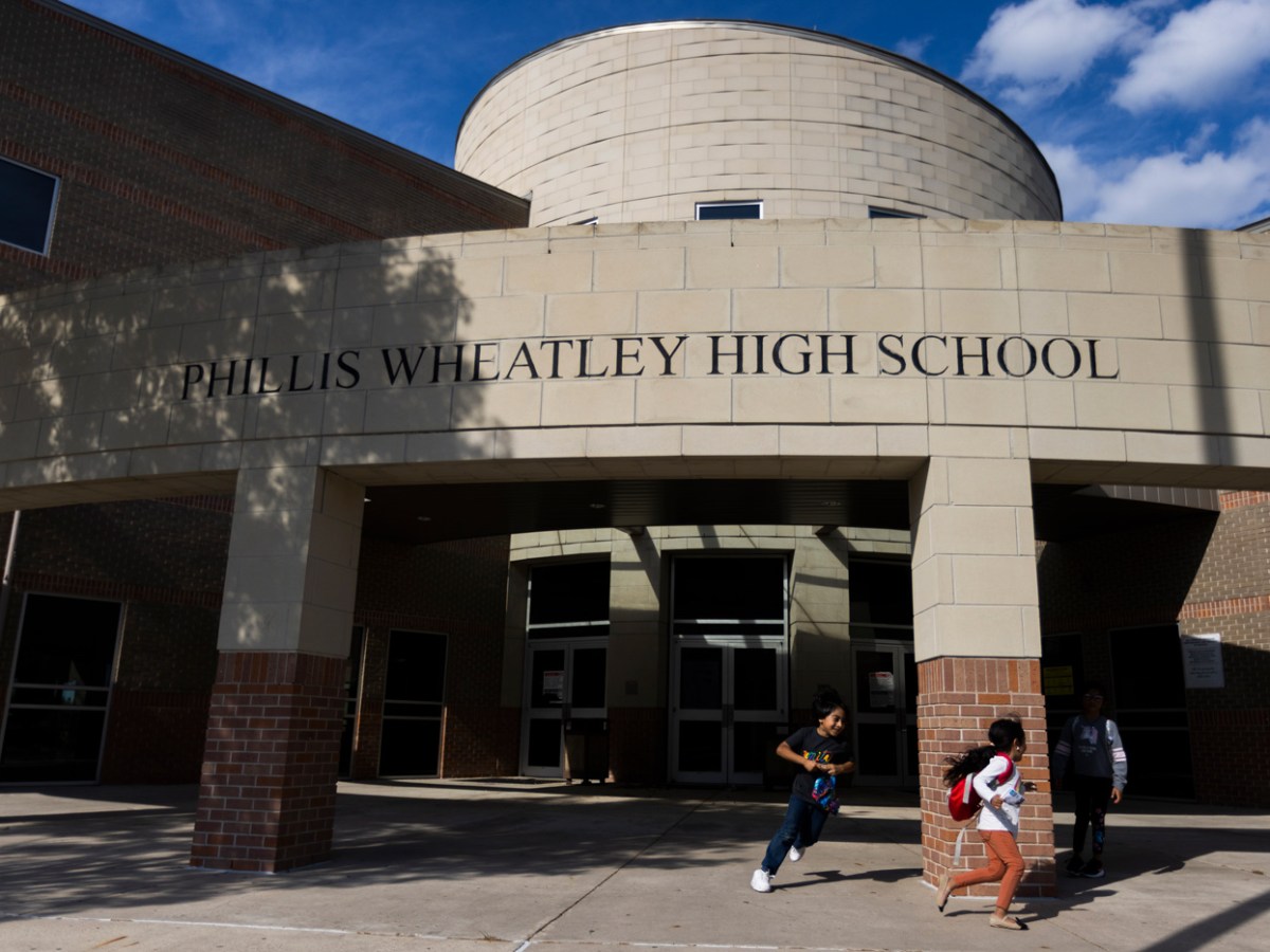 Children play around the entrance of a school.