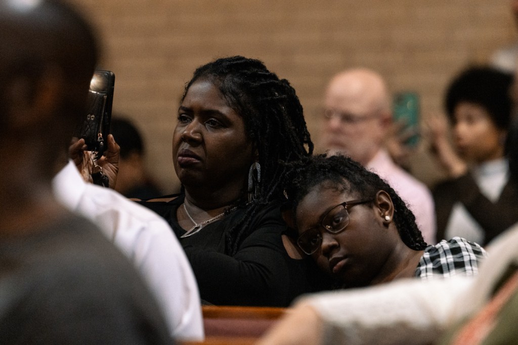 Mother and child listen to a speaker during a townhall.