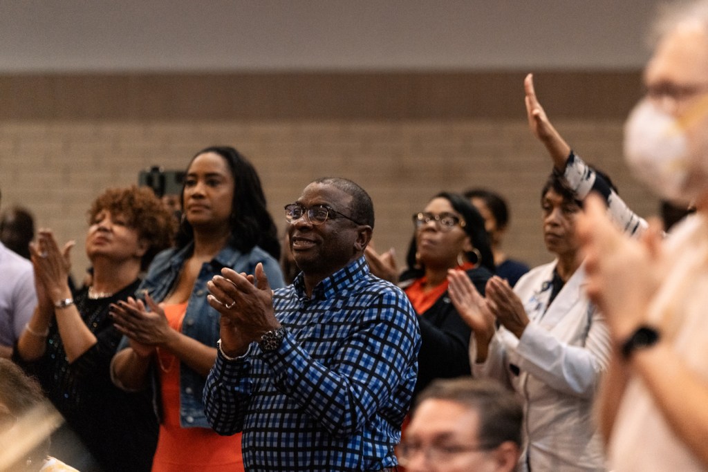 Attendees cheer during a townhall.