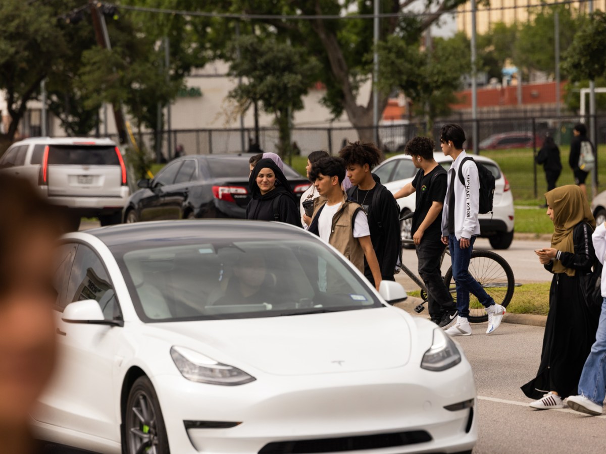 Students try to cross a busy street