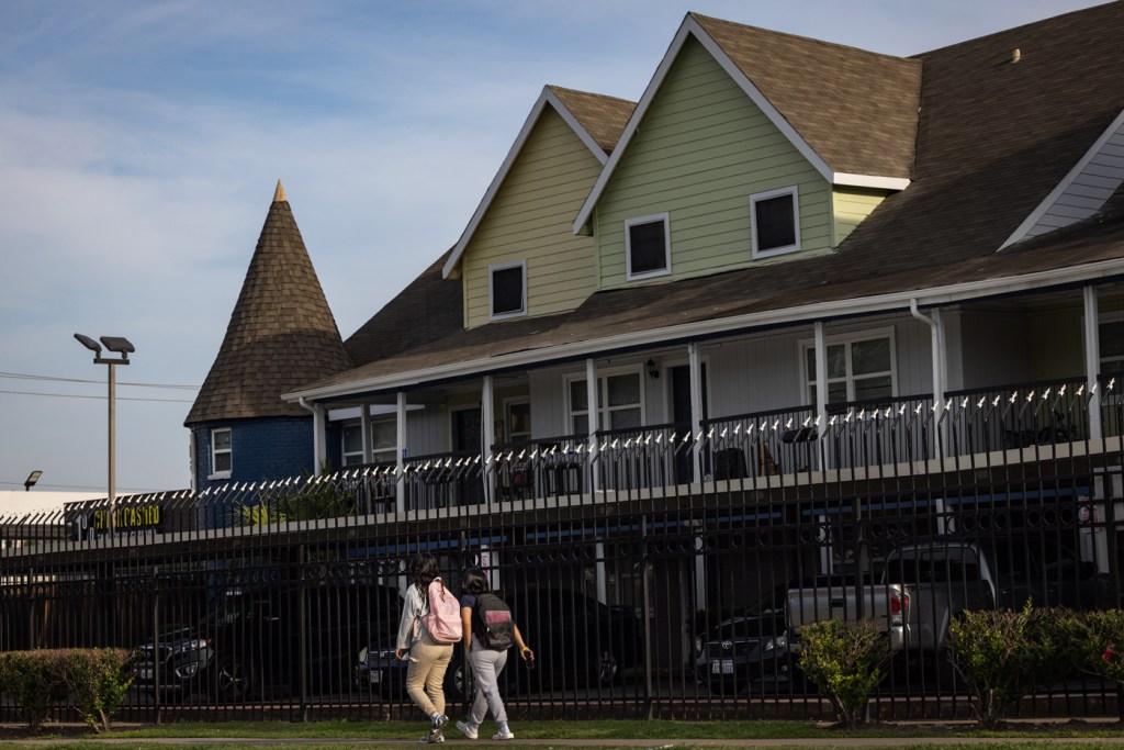 Students with backpacks walk to school.