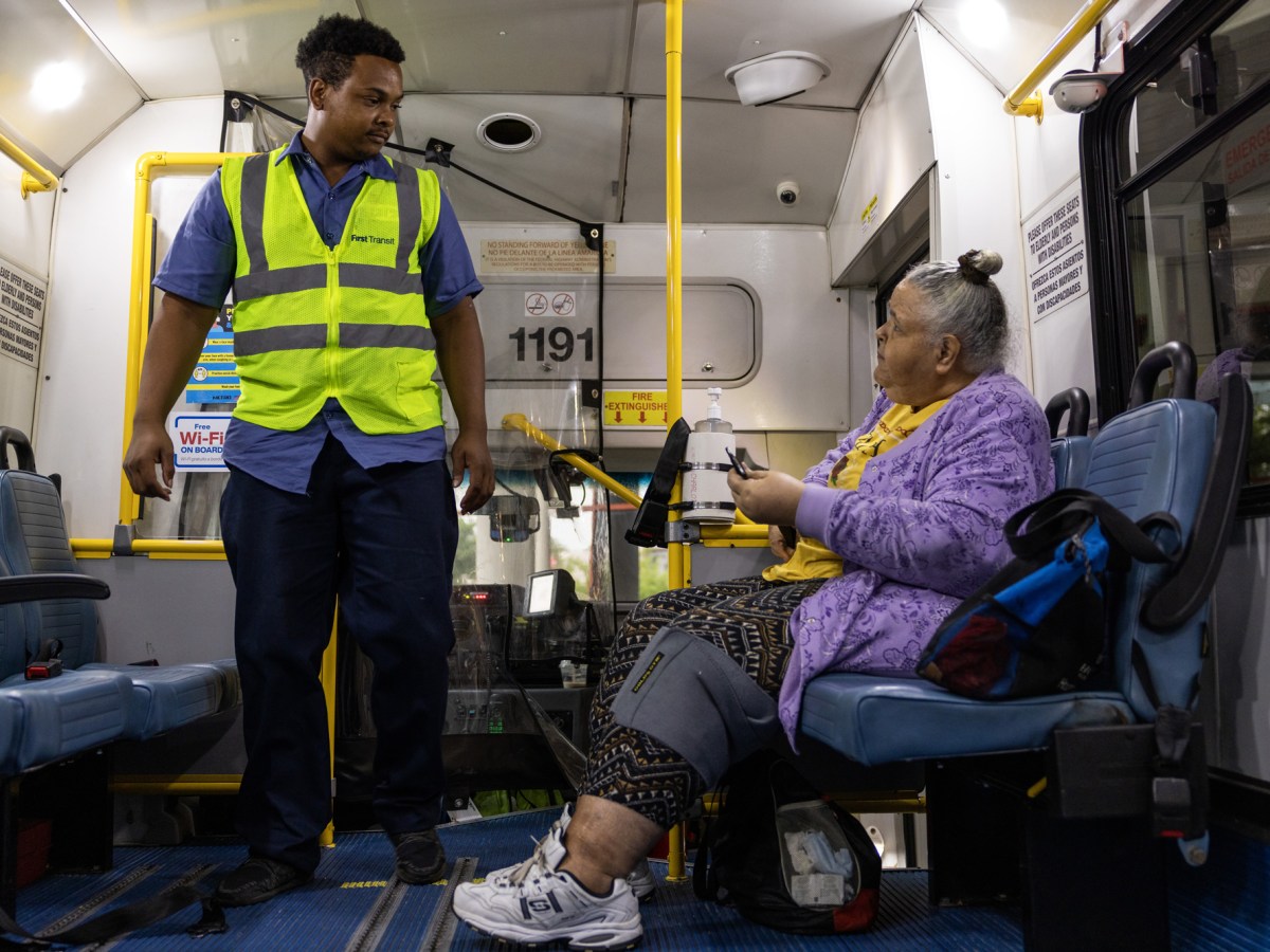 Joseph Coleman, at left, checks in on Shari Quattlebaum before starting the METROLift ride outside of Metropolitan Multi-Service Center in Houston.