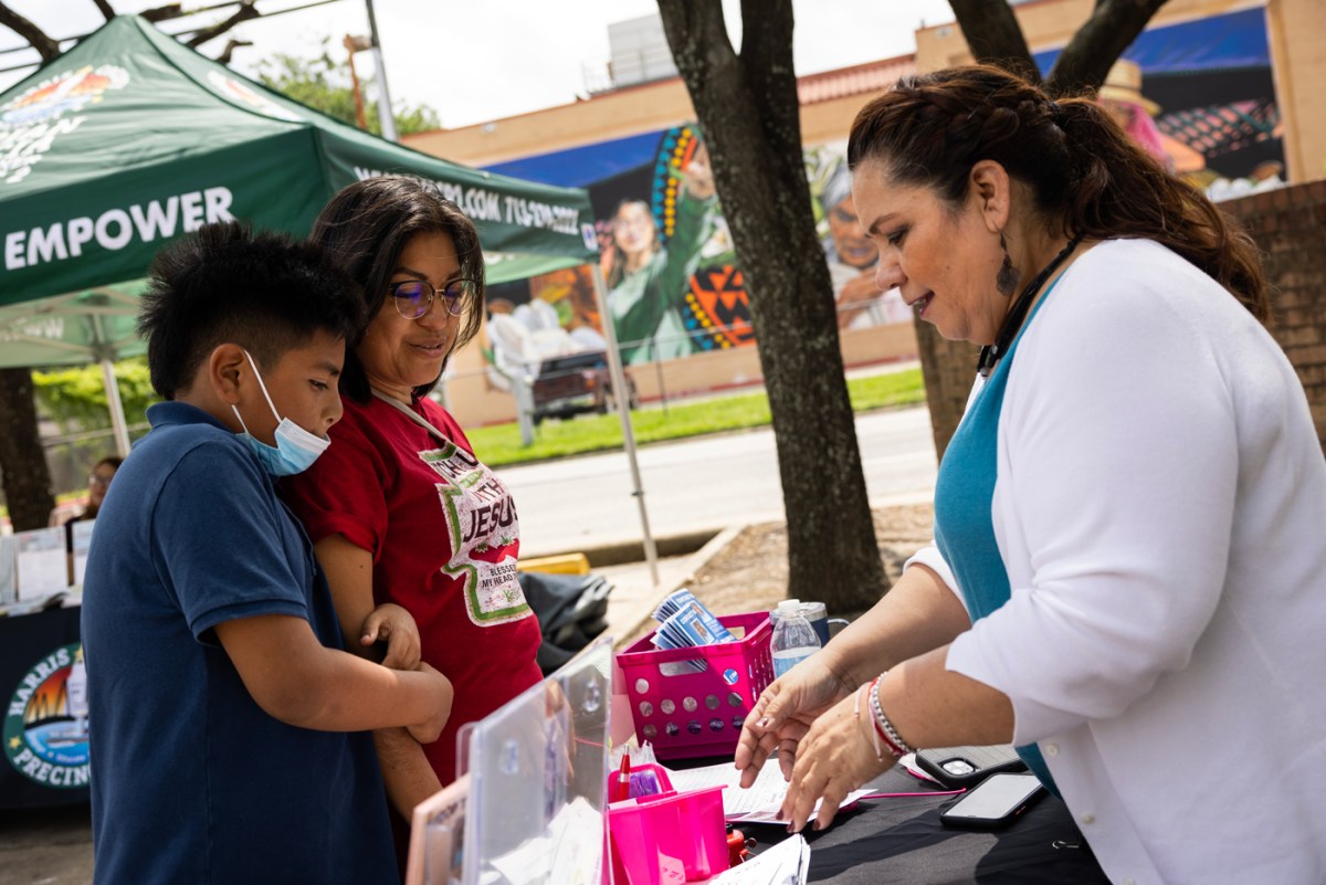 People talk at an informational kiosk
