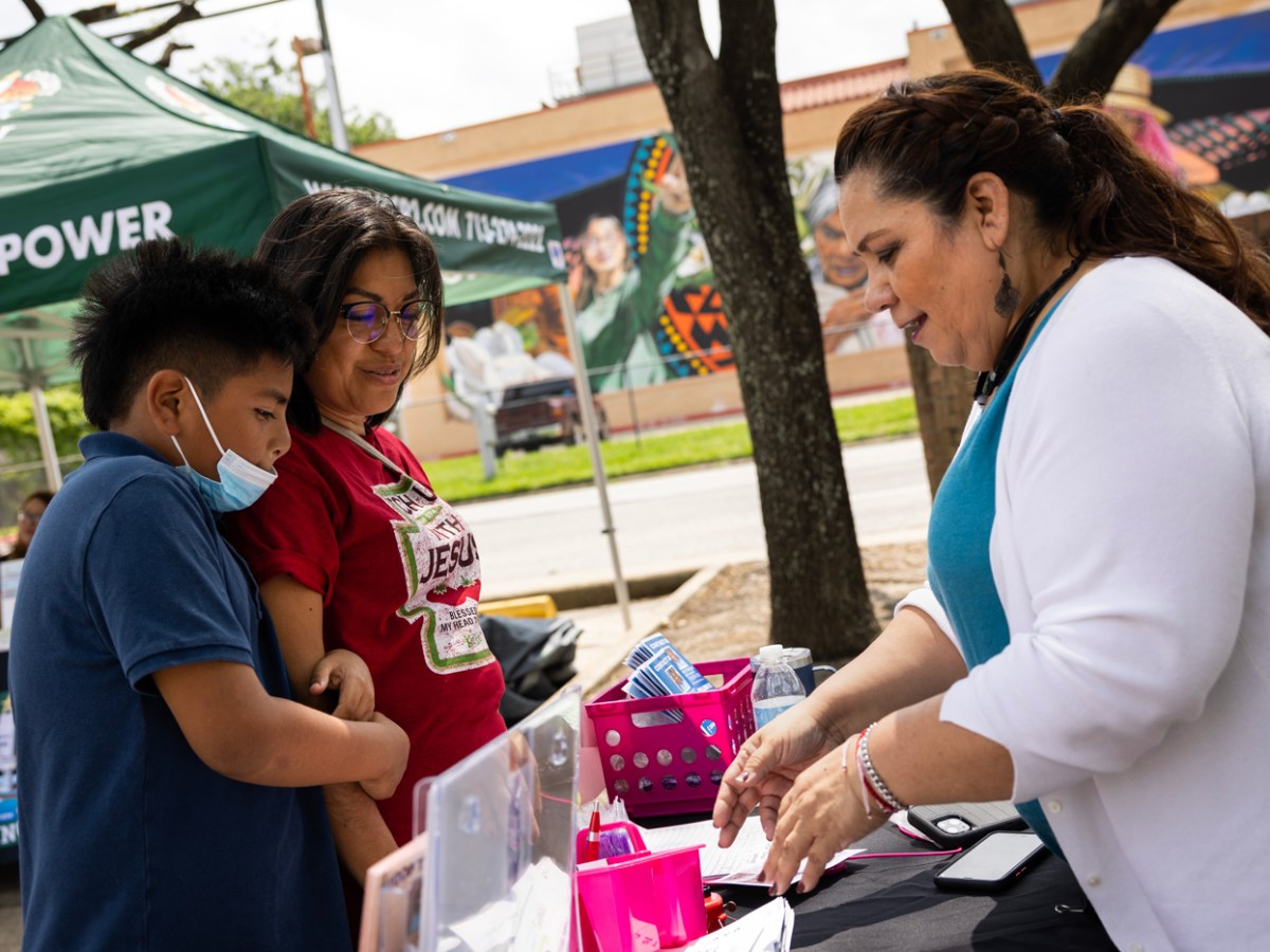 People talk at an informational kiosk