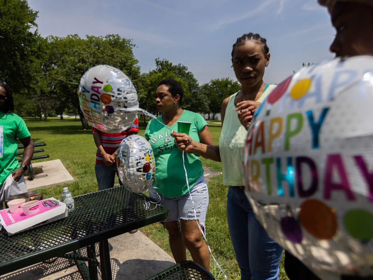 Family holds balloons in the park
