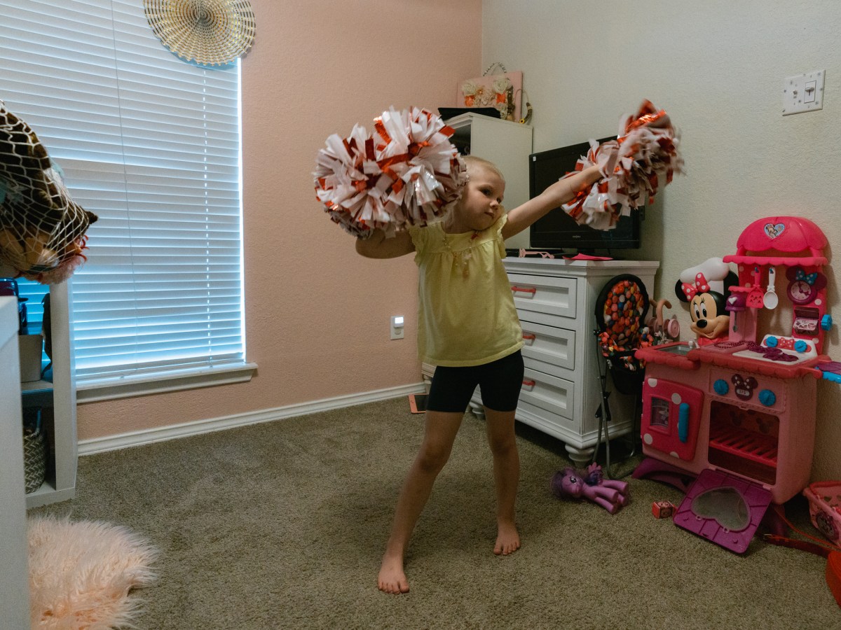 Girl with cheerleader pom poms