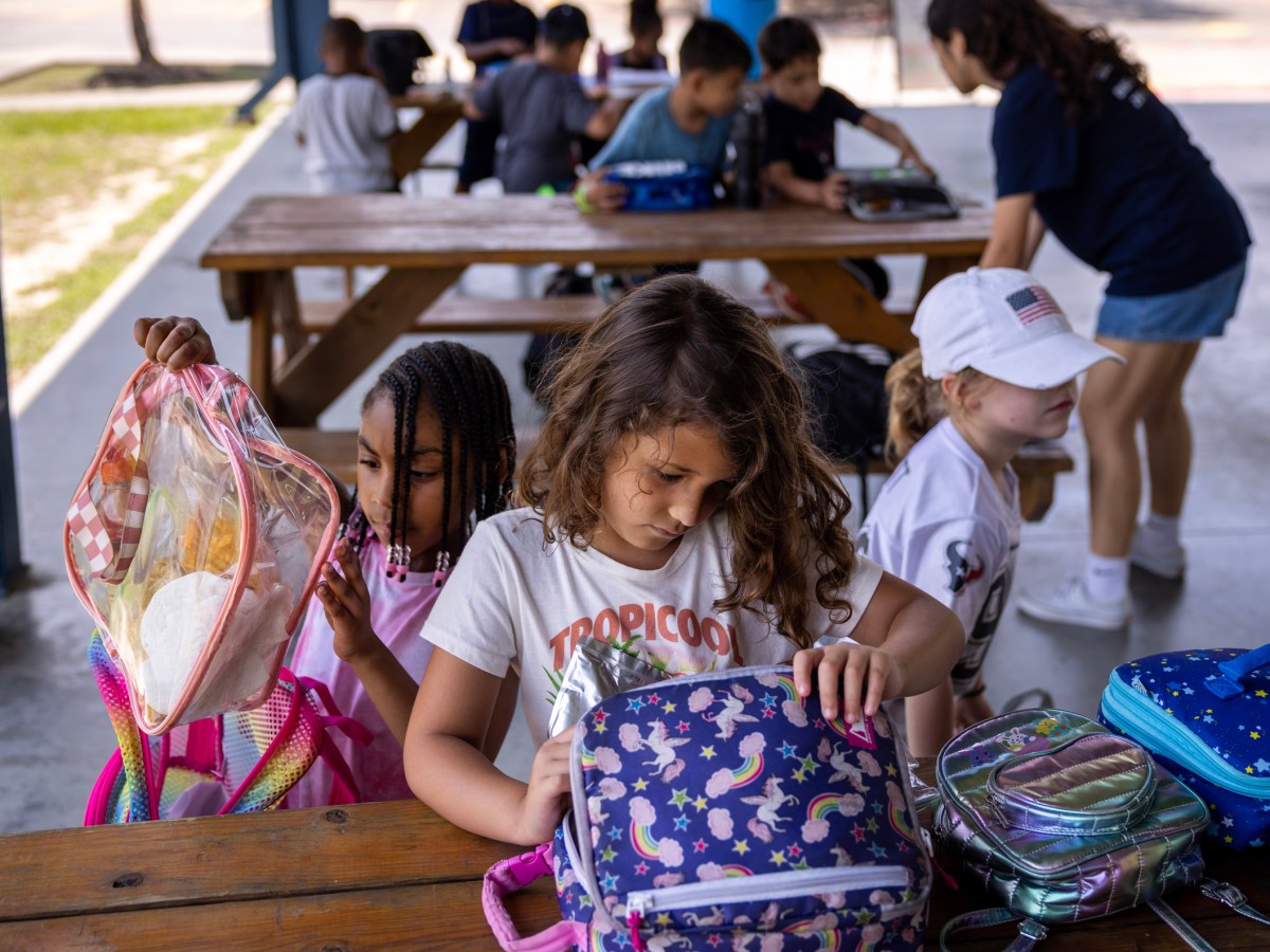 Little girls open lunch boxes