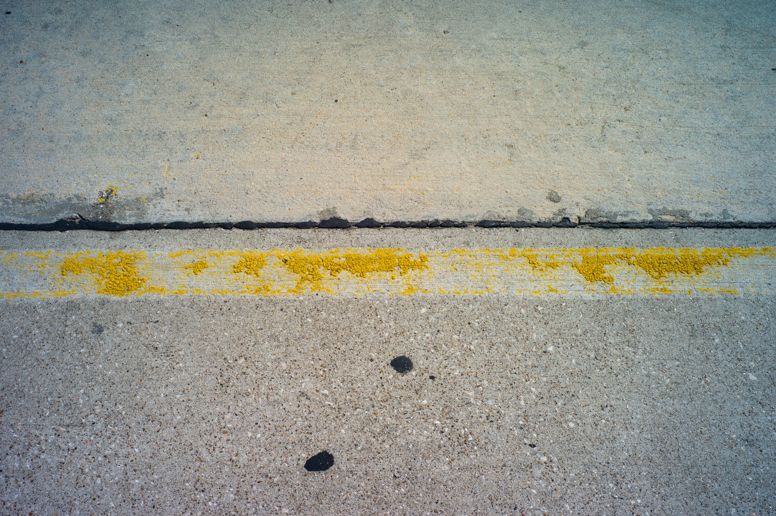 Photo of the road with worn out road stripes making it hard to see the road stripes
