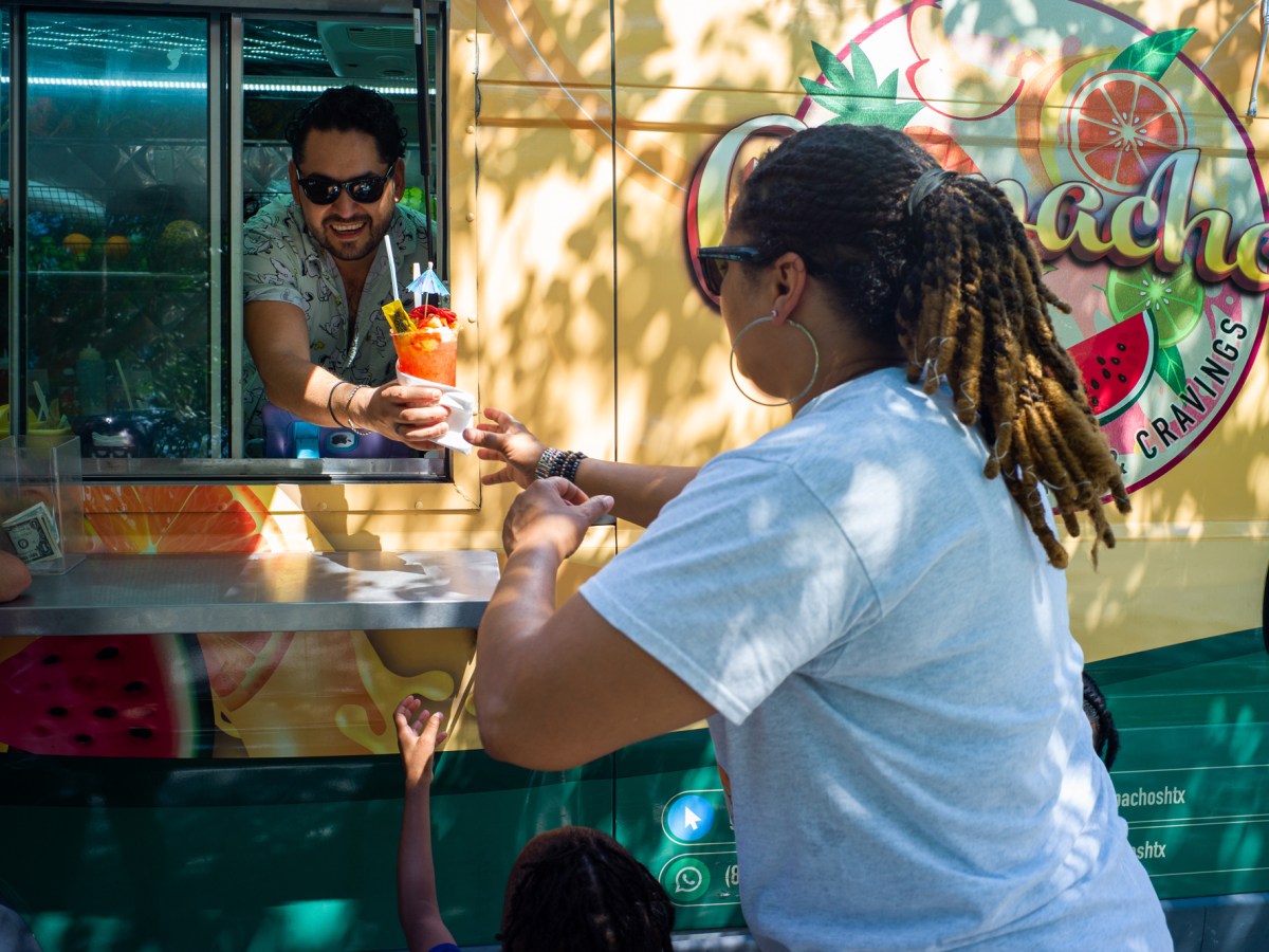 A woman receives her drink at Gaspachos food truck in Houston