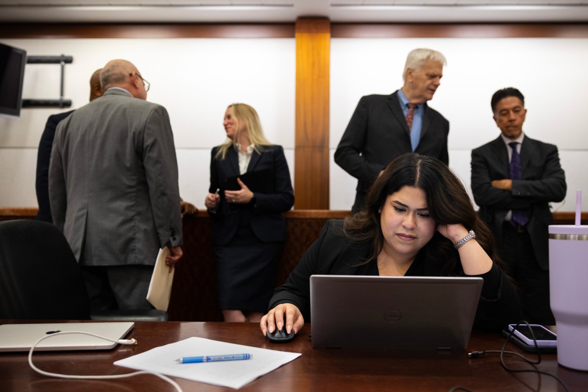 Lawyers line up behind Nidia Ventura to speak to her about their clients' felony cases at the Harris County Criminal Justice Center.