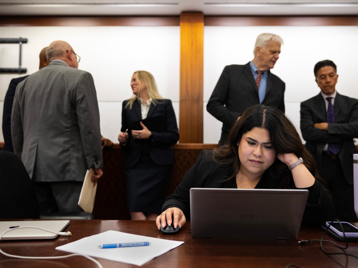 Lawyers line up behind Nidia Ventura to speak to her about their clients' felony cases at the Harris County Criminal Justice Center.