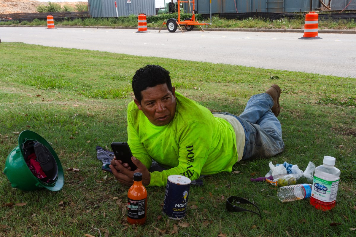 Miguel Hernandez, 47, escapes the heat under the shade of a tree