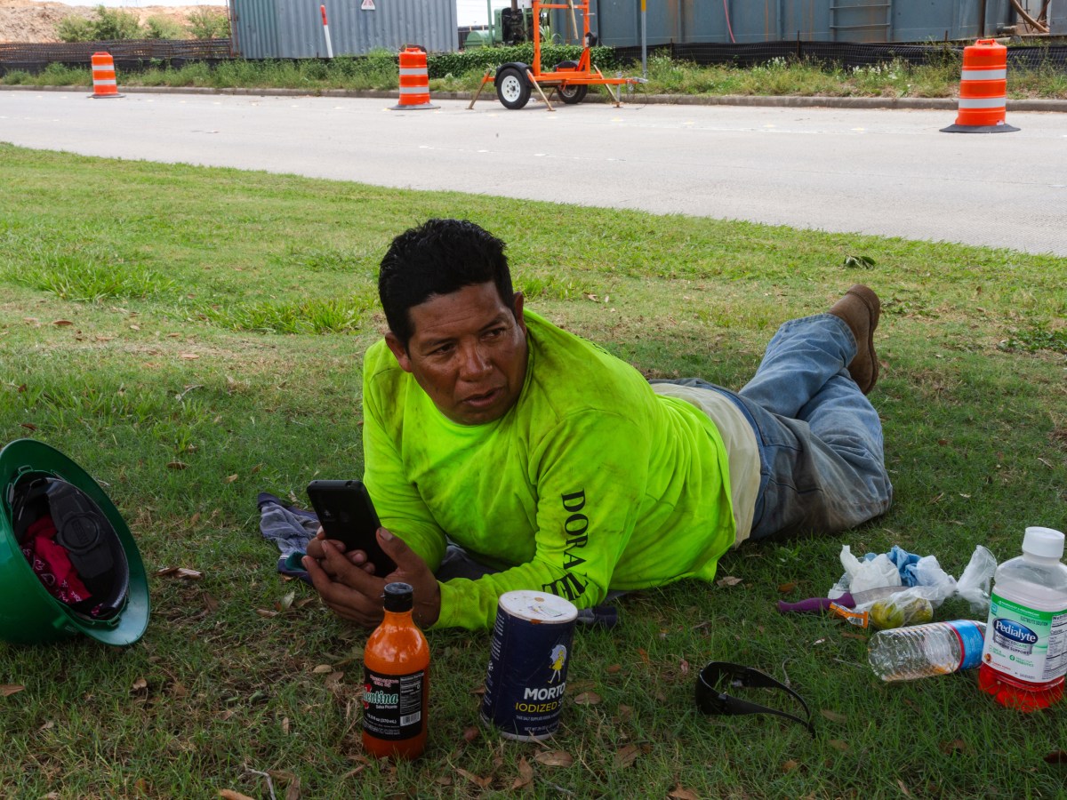 Miguel Hernandez, 47, escapes the heat under the shade of a tree