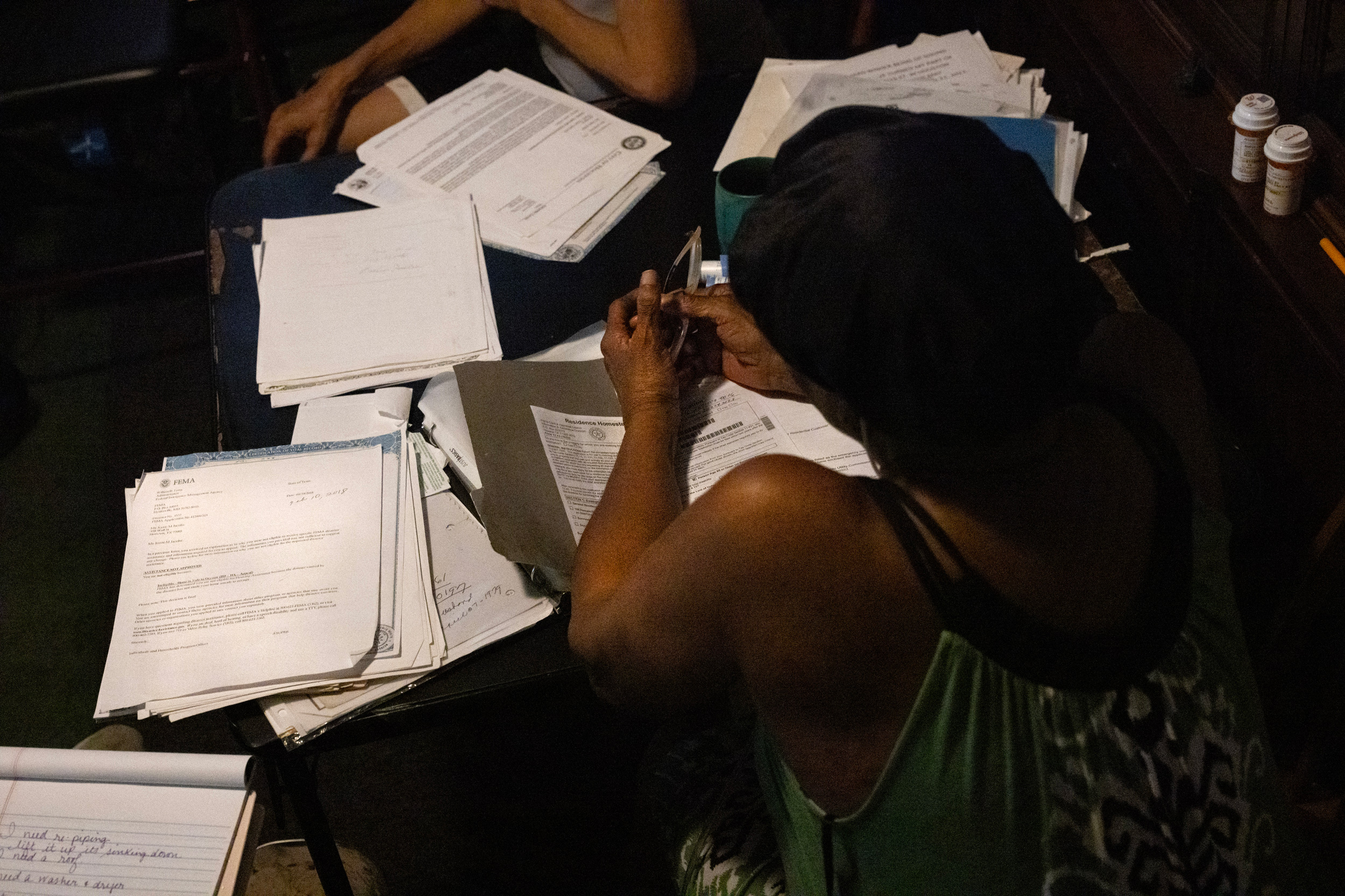Jessie Jacobs looks over stacks of papers regarding her damaged home