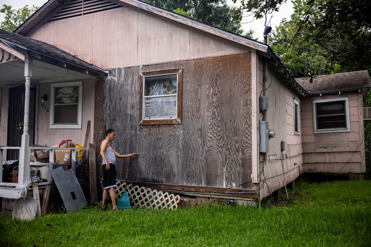 Tracey Wisher points out a section of rotting wood side paneling of his sister Jessie Jacobs’s home