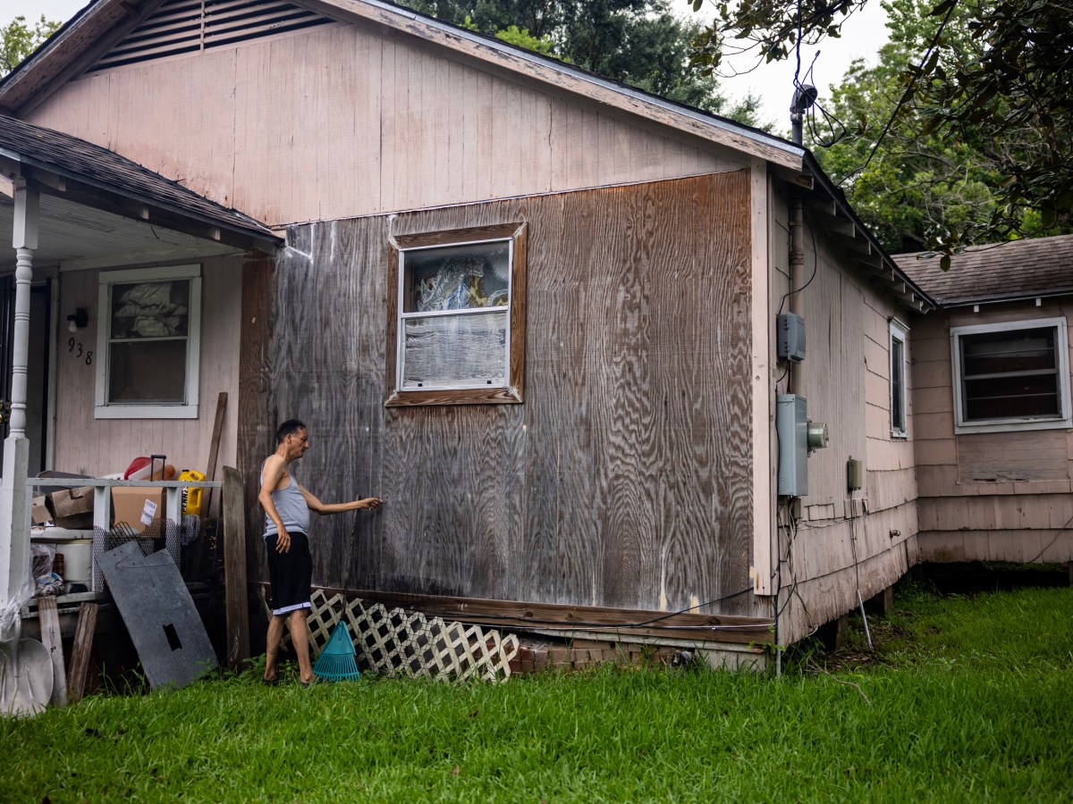 Tracey Wisher points out a section of rotting wood side paneling of his sister Jessie Jacobs’s home
