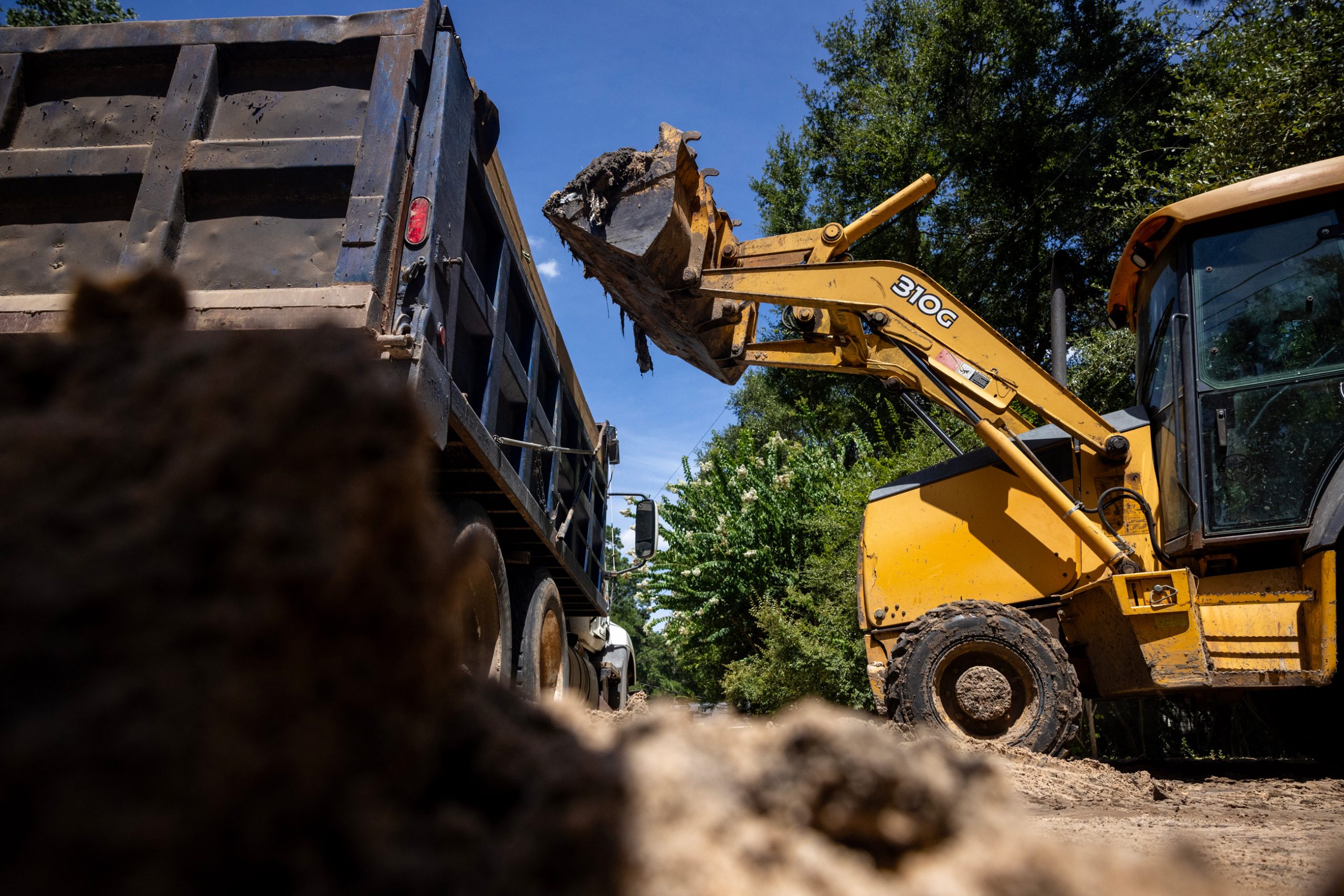 Josh Hellard loads silt onto a dump truck in Lake Forest Falls
