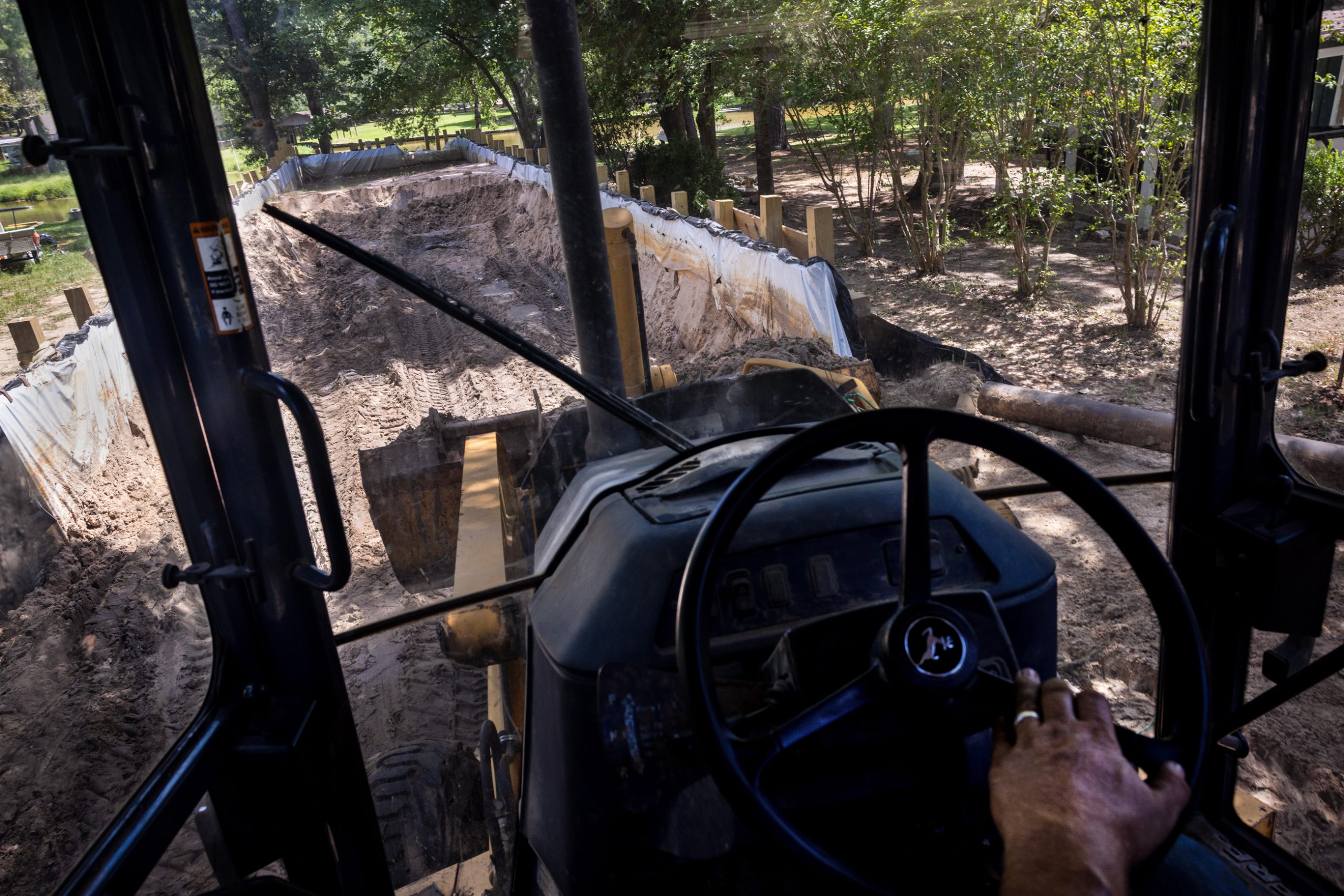 Josh Hellard loads silt onto a dump truck, Thursday, July 13, 2023, in Lake Forest Falls.