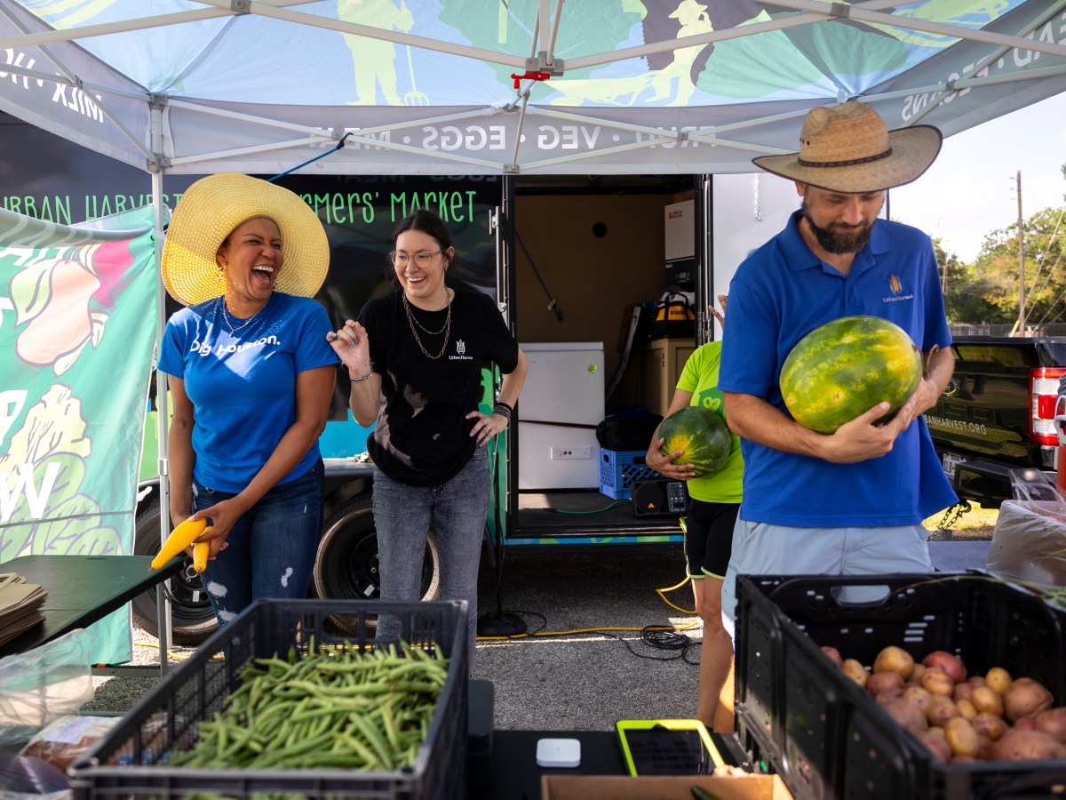 Urban Harvest staff members prepare for a group photo during a farmers market