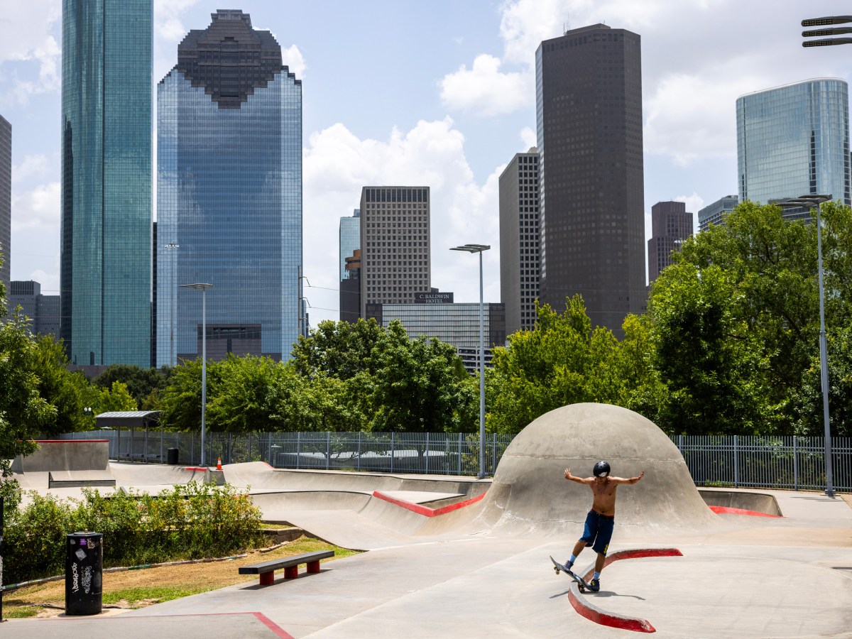 A skateboarder with downtown Houston in the background