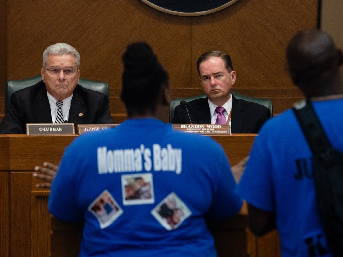 Tracey Woodson Smith and her husband, Kevin, hold a poster of their son, Kevin Jr., as they speak to members of the Texas Commission on Jail Standards