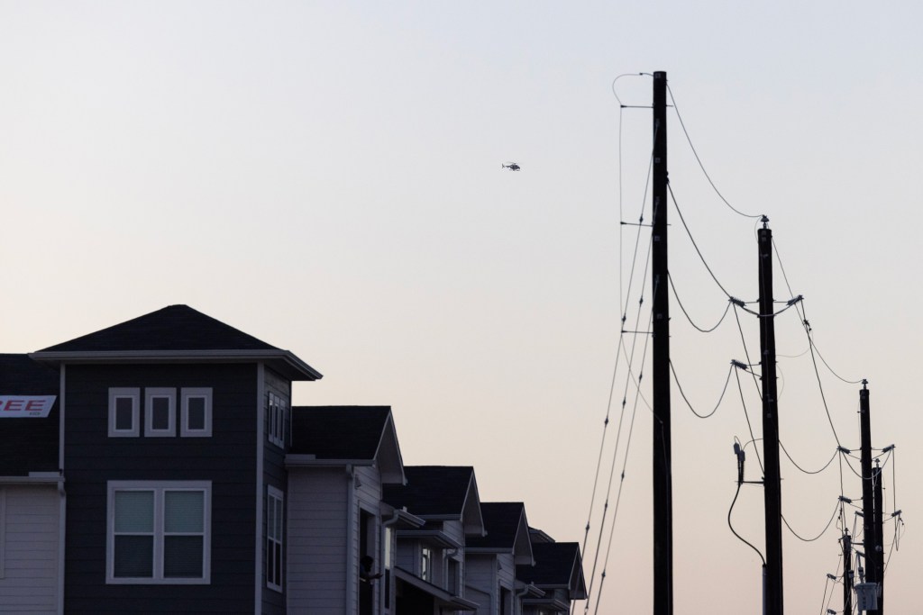 A helicopter flies over a standoff in Humble where a gunman shot and injured two deputies Thursday evening.