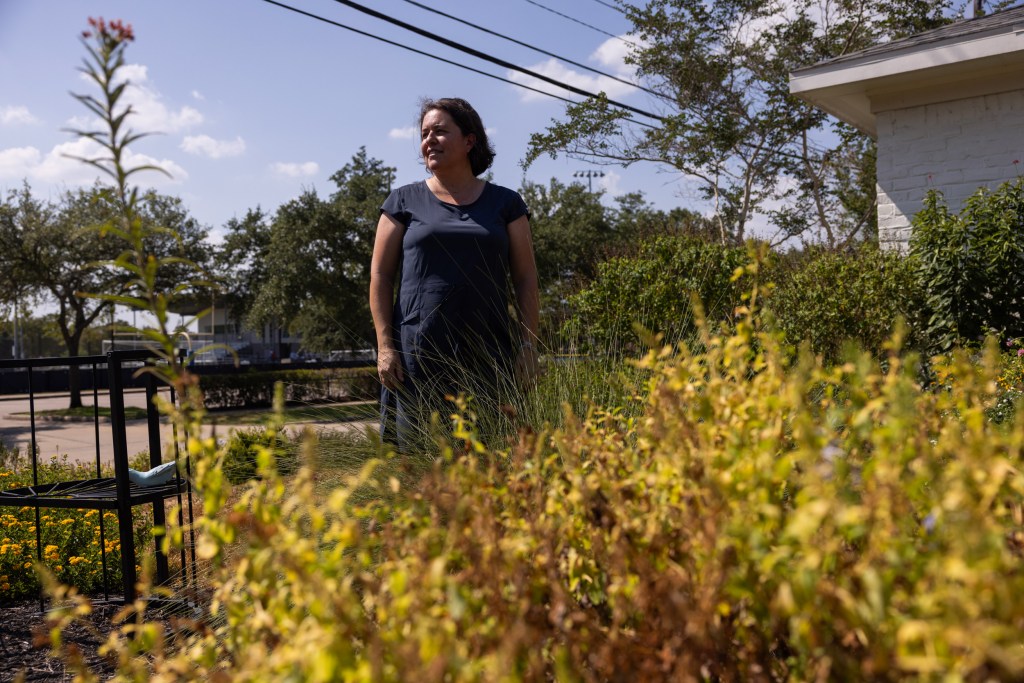 Claudia Schnelle poses for a portrait in her xeriscaped front yard with drought-tolerant plants