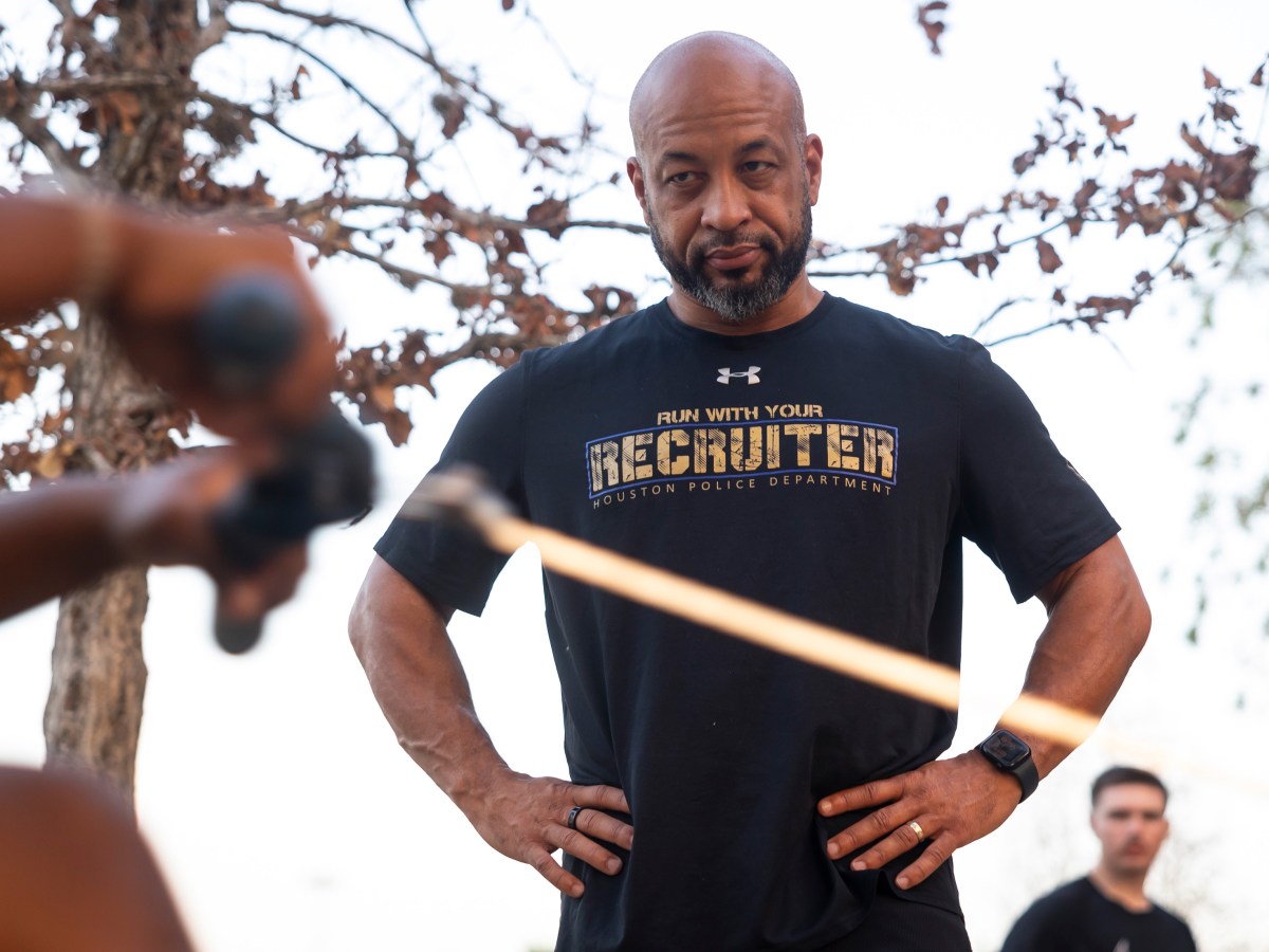 Houston Police Department Sgt. James Louis watches a potential recruit row during an early morning recruiting event for aspiring police officers at Memorial Park in Houston.