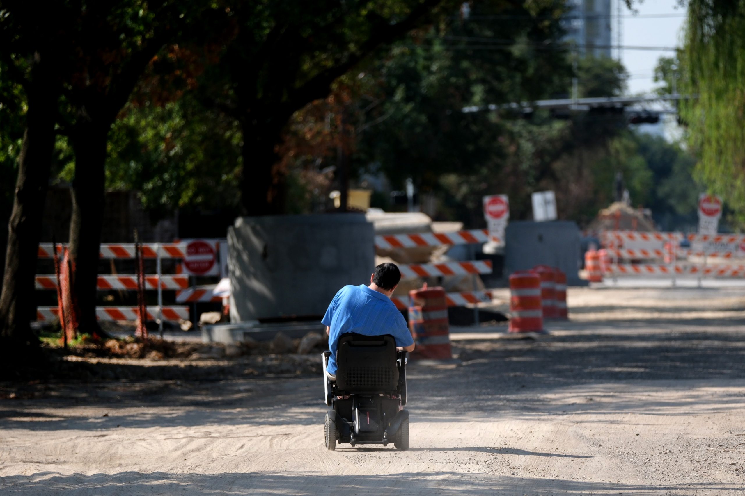 A man in a motorized chair near Woodhead Street makes his way through the chaotic ongoing infrastructure repairs in Houston.