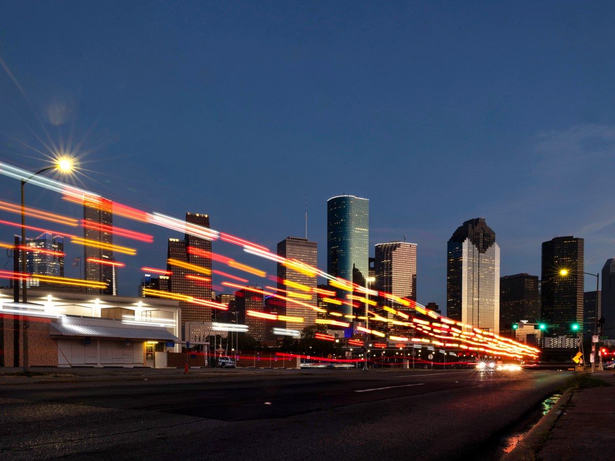 The lights of a passing ambulance on Houston Avenue leave a pattern in front of downtown Houston
