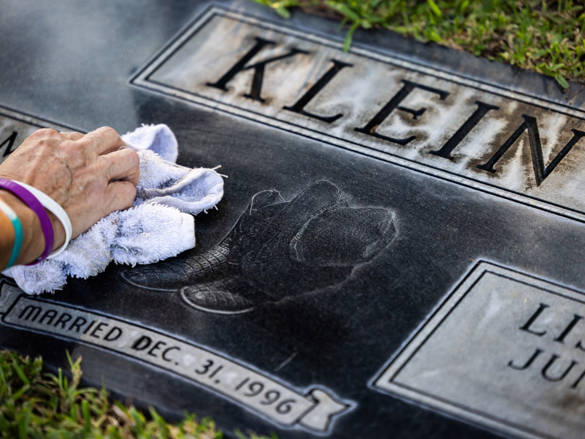 Debbie Chapa cleans the tombstone of her son-in-law, Walter Klein, at a Magnolia cemetery in September. Walt died in 2018 after having a heart attack in the Harris County Jail — but his death was never reported to the state.