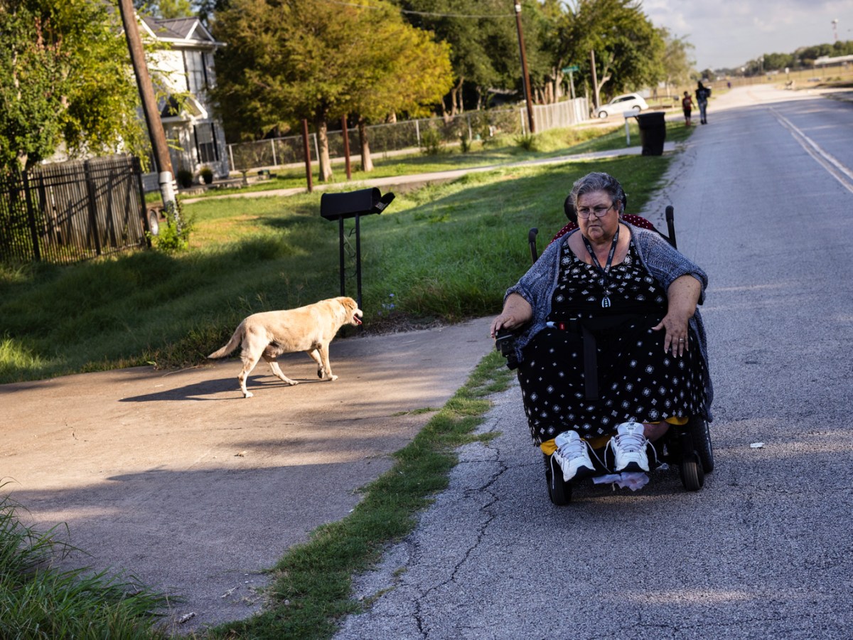 Louis Mendez passes by a dog while riding down the street while giving a tour of her neighborhood, Friday, Sept. 22, 2023, in Houston. The lack of consistent and safe sidewalks forces her to ride on the road.