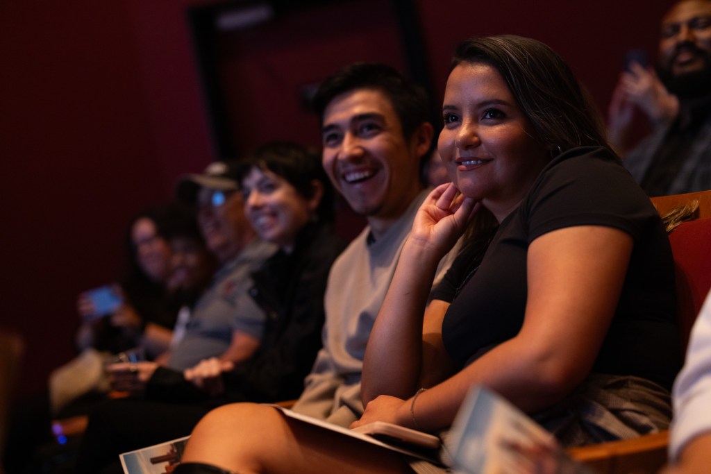 Valeria Alvarado, at right, and Moises Mendoza watch as reporters present during the Houston Landing Live event.