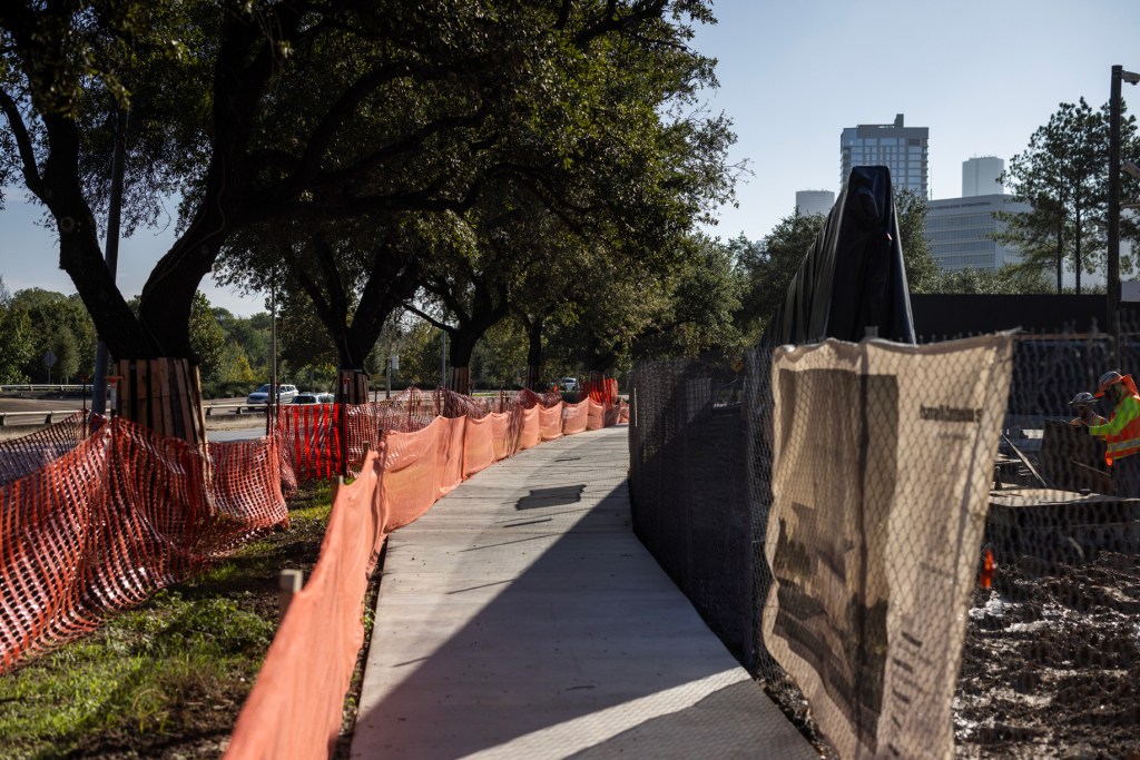 Live oak trees and a newly constructed sidewalk line the northern side of the soon to come Ismail Center Houston on Allen Parkway