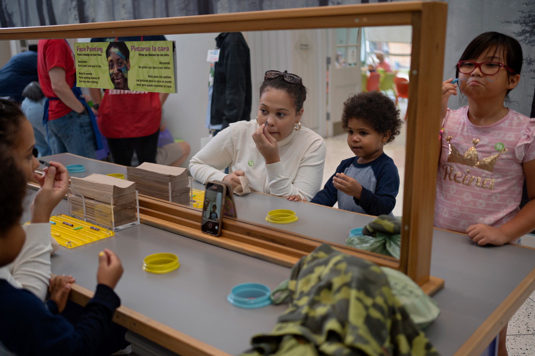 Tiye McKethe and her son paint their faces during the Indigenous People's Day commemoration at the Children’s Museum Houston