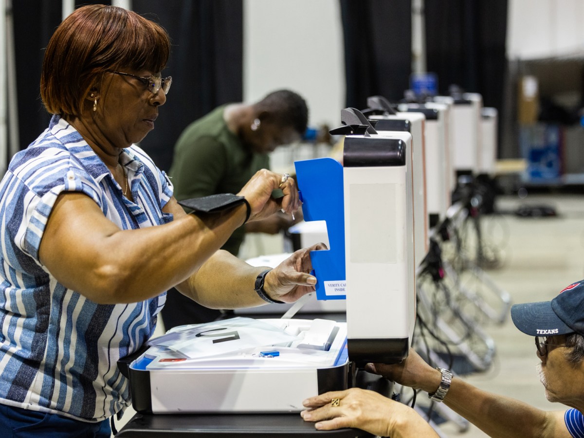Volunteers set up voting machines in preparation for early voting and Election Day at the NRG Arena