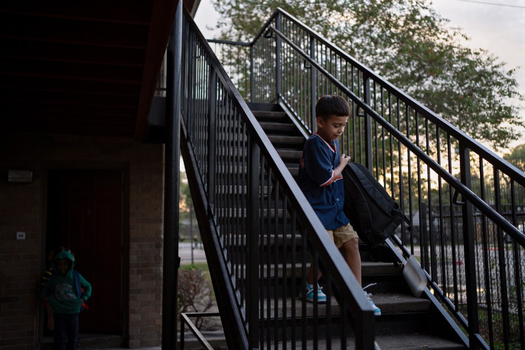 Vivian Alexander’s son walks down the stairs outside their home on the way to school next door at Roderick Paige Elementary, October 20, 2023, in Houston.