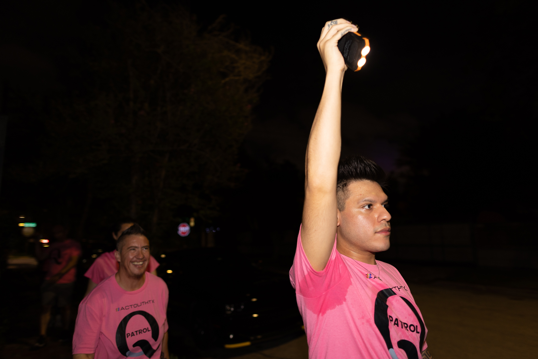 Q Patrol member and ActOutHTX co-founder Marc Meave, right, uses a flashlight to light up the way as members of the Q Patrol walk Montrose streets, Friday, Oct. 27, 2023, in Houston. 