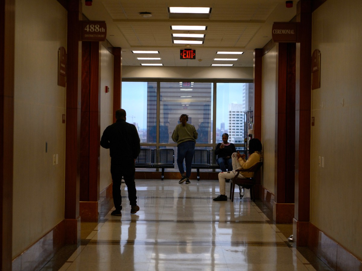 People wait Tuesday outside of the 488th District Court at the Harris County Criminal Justice Center in downtown Houston.