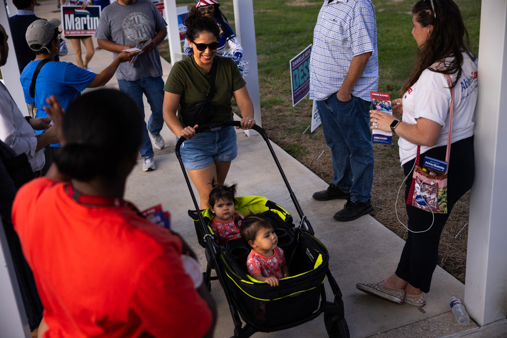 Joanna Castilleja, center top, carts her daughters Cati, and Rosi Tejeda, center bottom, as she goes to vote at the Metropolitan Multi-Service Center on Election Day