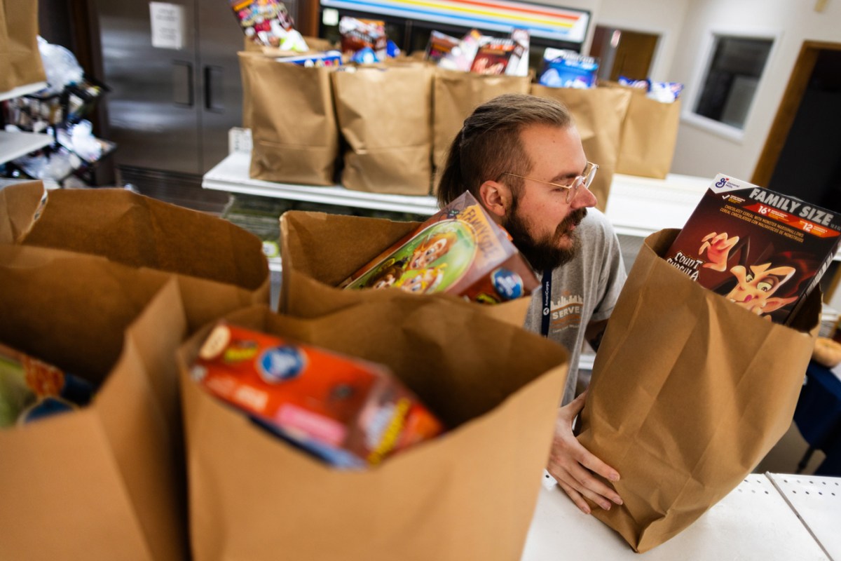 AmeriCorps member Rain Jones, 24, grabs prepared grocery bags to deliver to members of the community supported by the Catholic Charities Archdiocese of Galveston-Houston